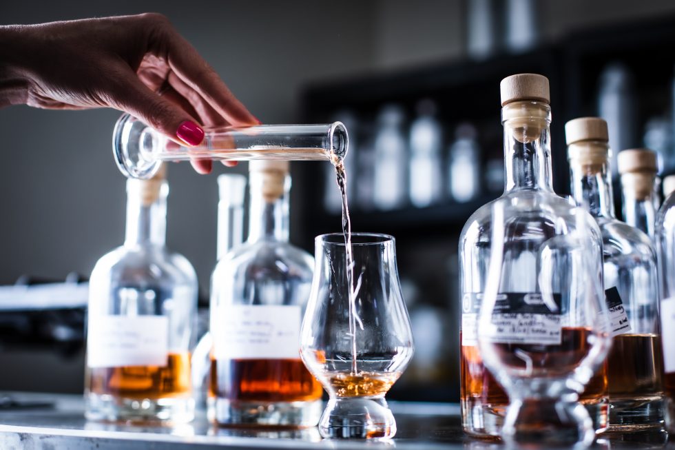Spirituose wird aus einer Flasche in ein Nosing-Glas gegossen